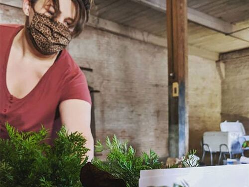 A woman wearing a mask and doing a freshbox delivery