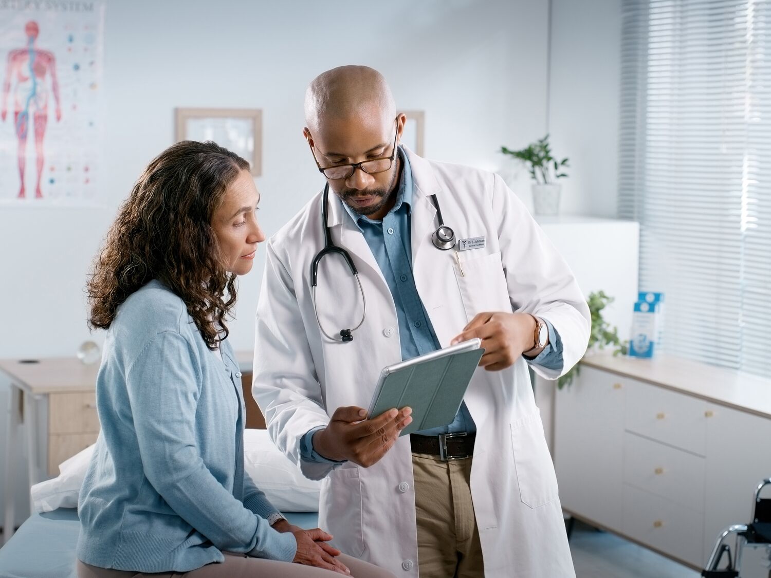 A doctor holding a tablet and showing to patient.
