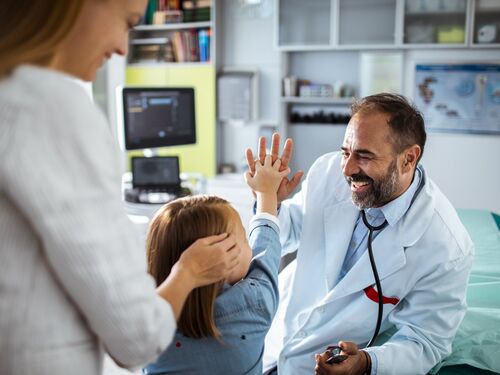A doctor high-fiving a child patient.