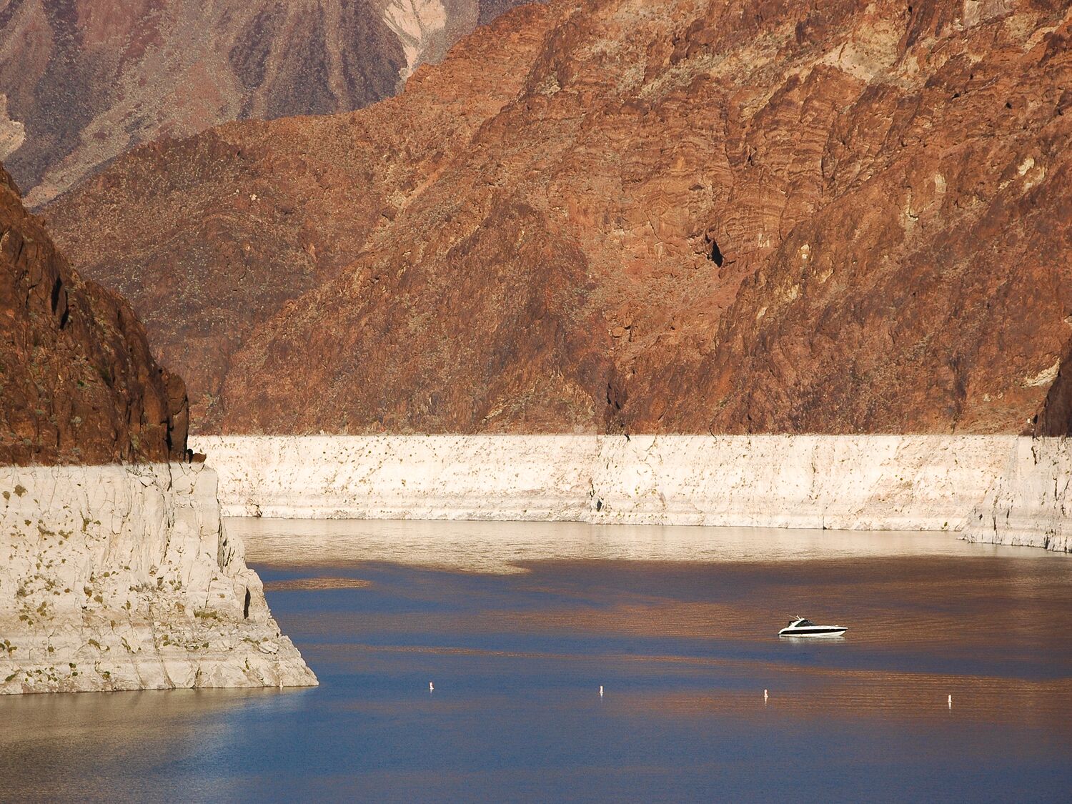 Small watercraft exploring Lake Mead near the top of the Hoover Dam, Nevada, USA.