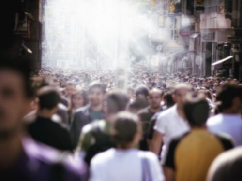 Large group of blurred motion people walking on busy city street