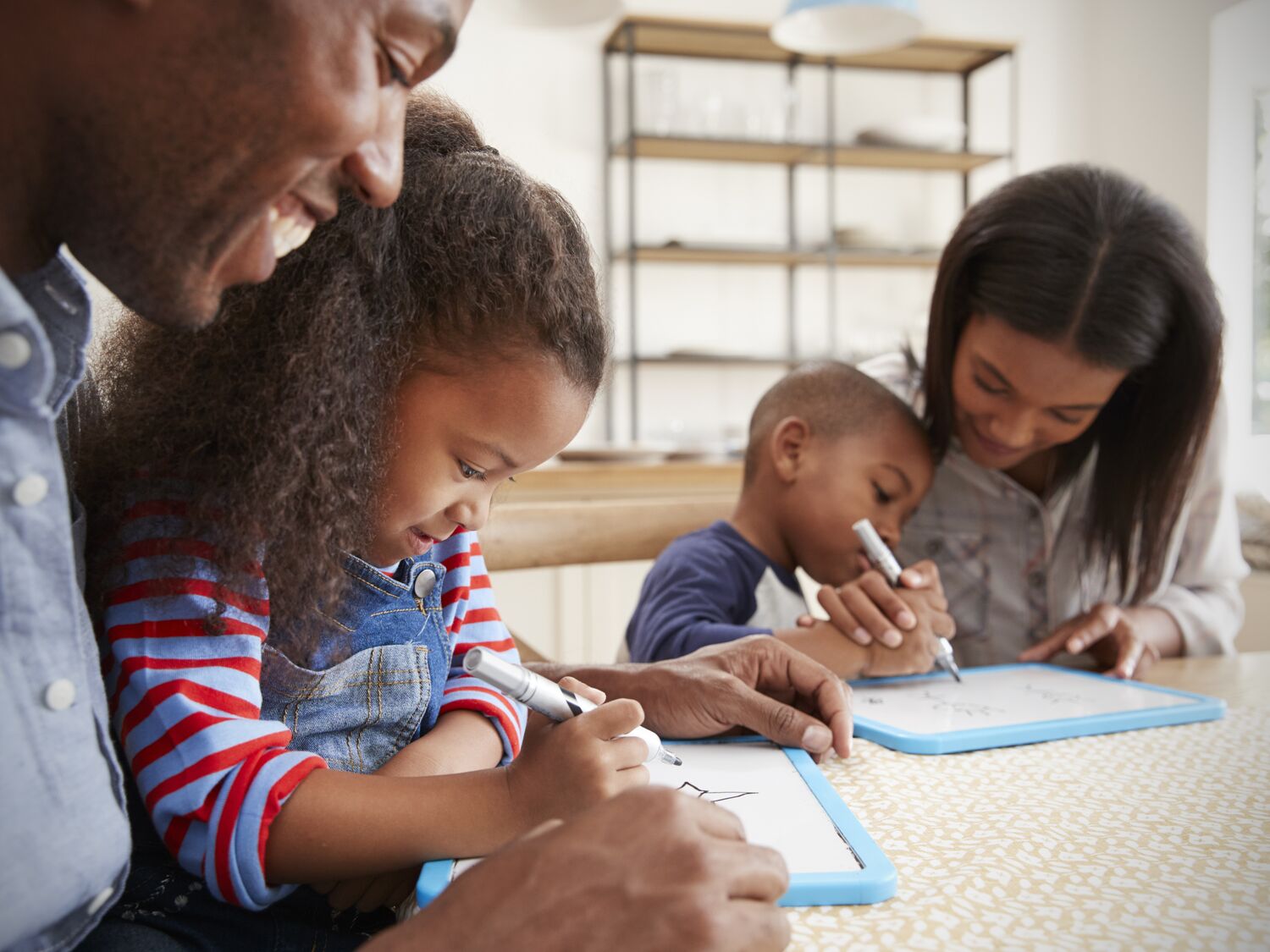 Parents And Children Drawing On Whiteboards At Table
