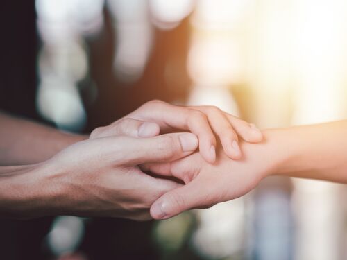 Two people joining hands.