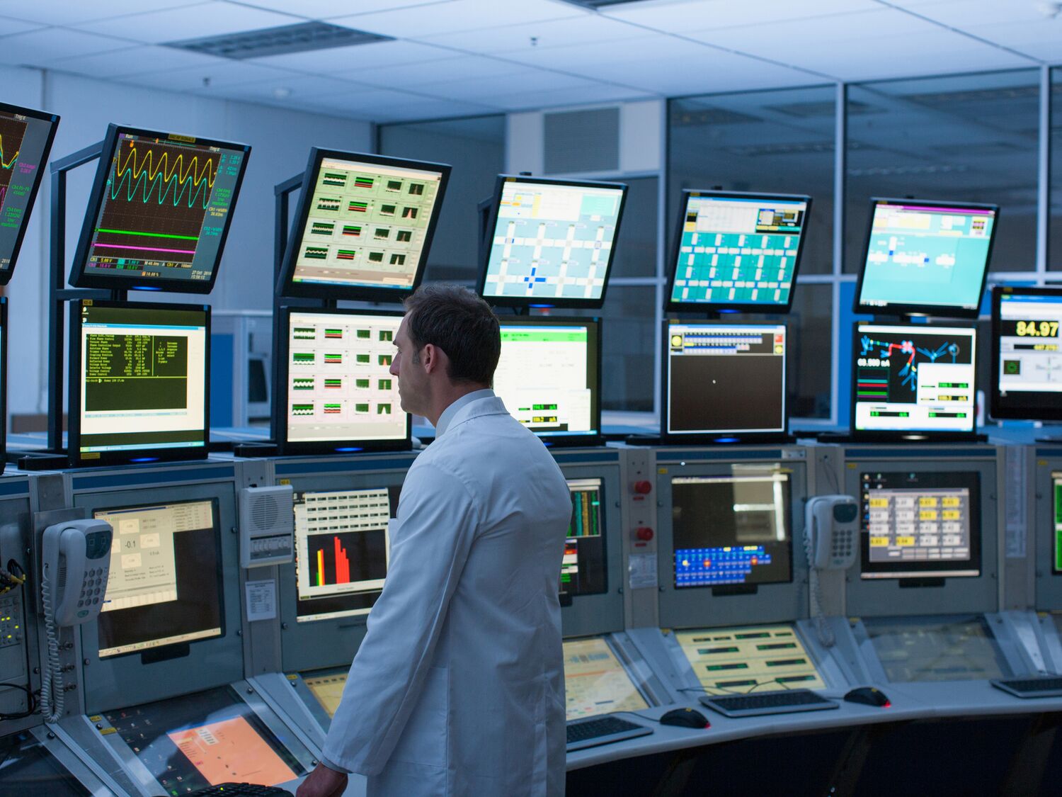 Scientist monitoring computers in control room.