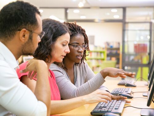Instructor explaining corporate software specific to trainees in computer class.