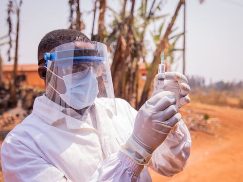 A doctor in Africa checks the vaccine syringe