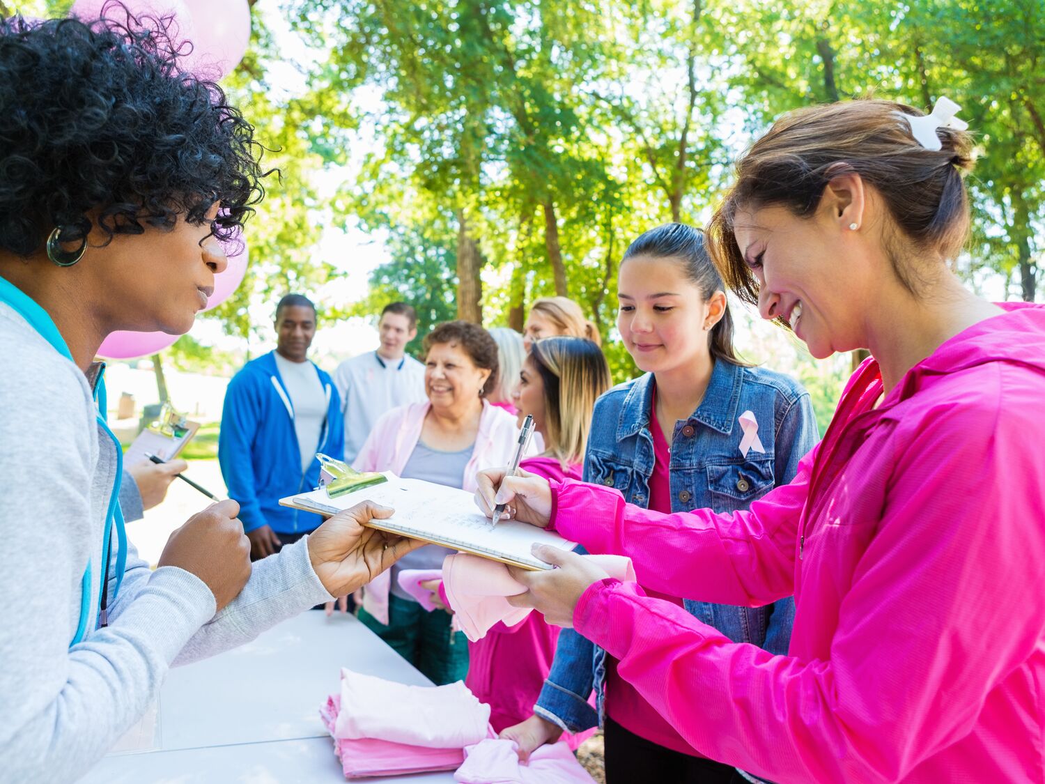 Diverse people registering for charity breast cancer awareness race