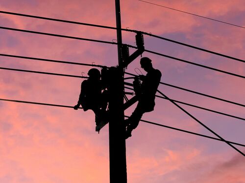 Electrician worker climbing electric power pole to repair the damaged power cable line problems after the storm. Power line support,Technology maintenance and development industry concept