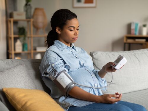 Pregnant Black Female Measuring Blood Pressure Having Low Tension Indoor.