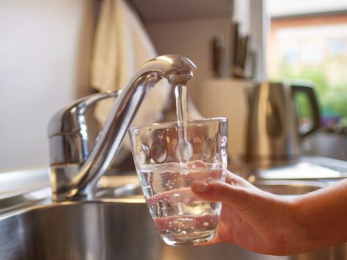 someone filling a glass of water