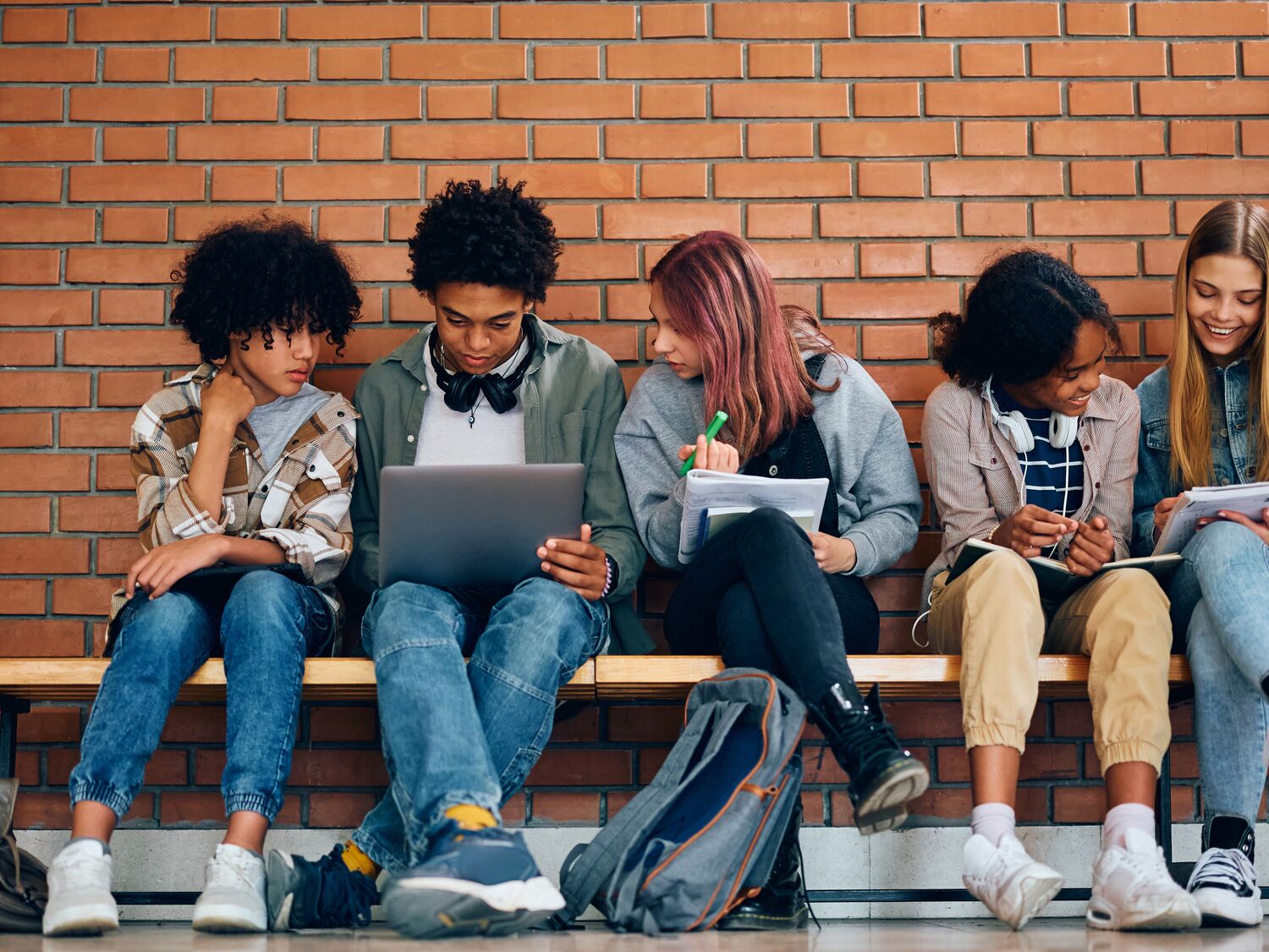 Multiracial group of high school students learning together at school.