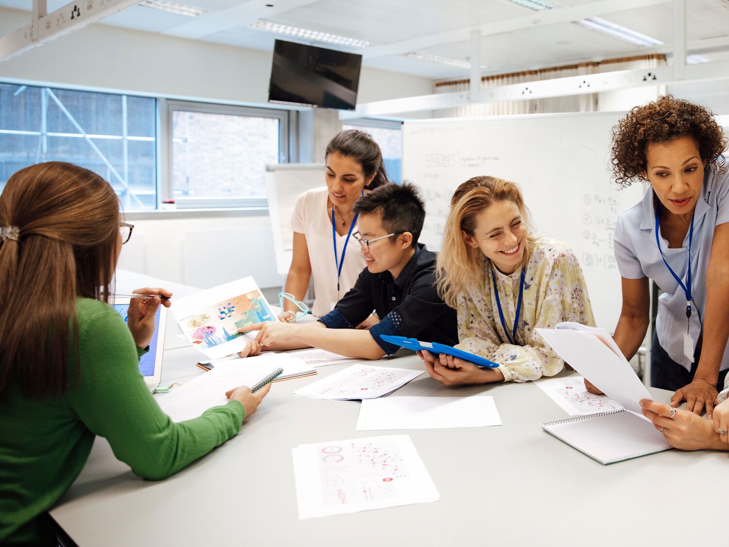 A group of people collaborating and looking at papers together.