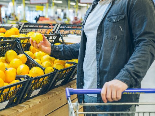 a man buying lemons at the supermarket