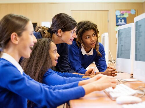 Group of multi ethnic students coding in a computer lab.