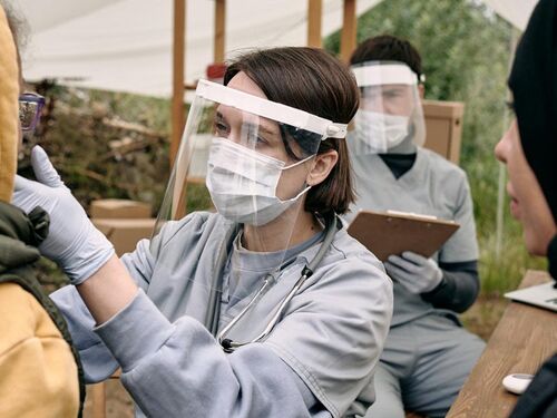 health care workers examining a patient in an outdoor setting