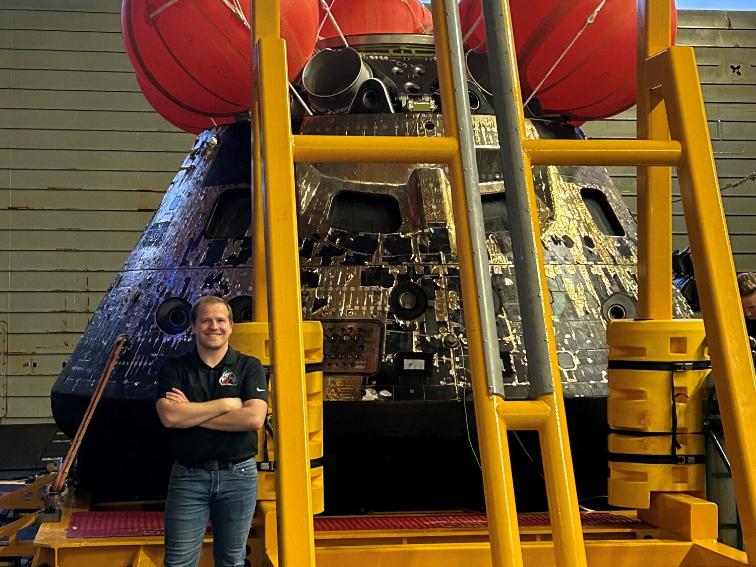 Former ACRP University Design Competition winner Jason Endsley stands beside Artemis II recovery equipment