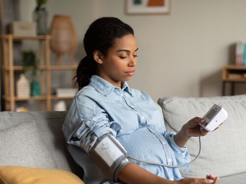 Pregnant Black Female Measuring Blood Pressure Having Low Tension Indoor.