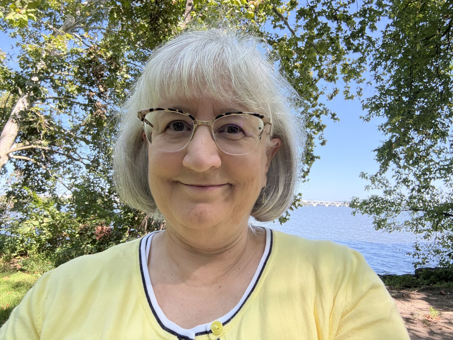 Amy Stearns under a tree in front of water and a mountain