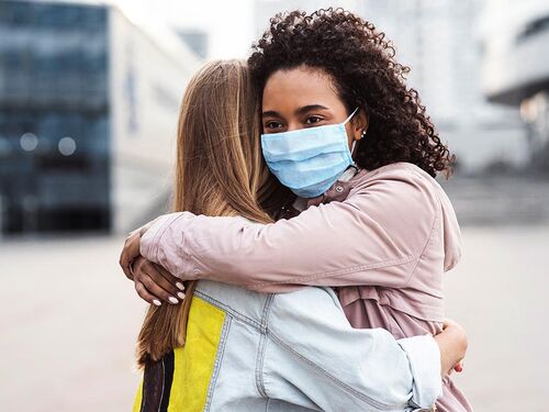 girl in mask hugging friend no logo (1).jpg