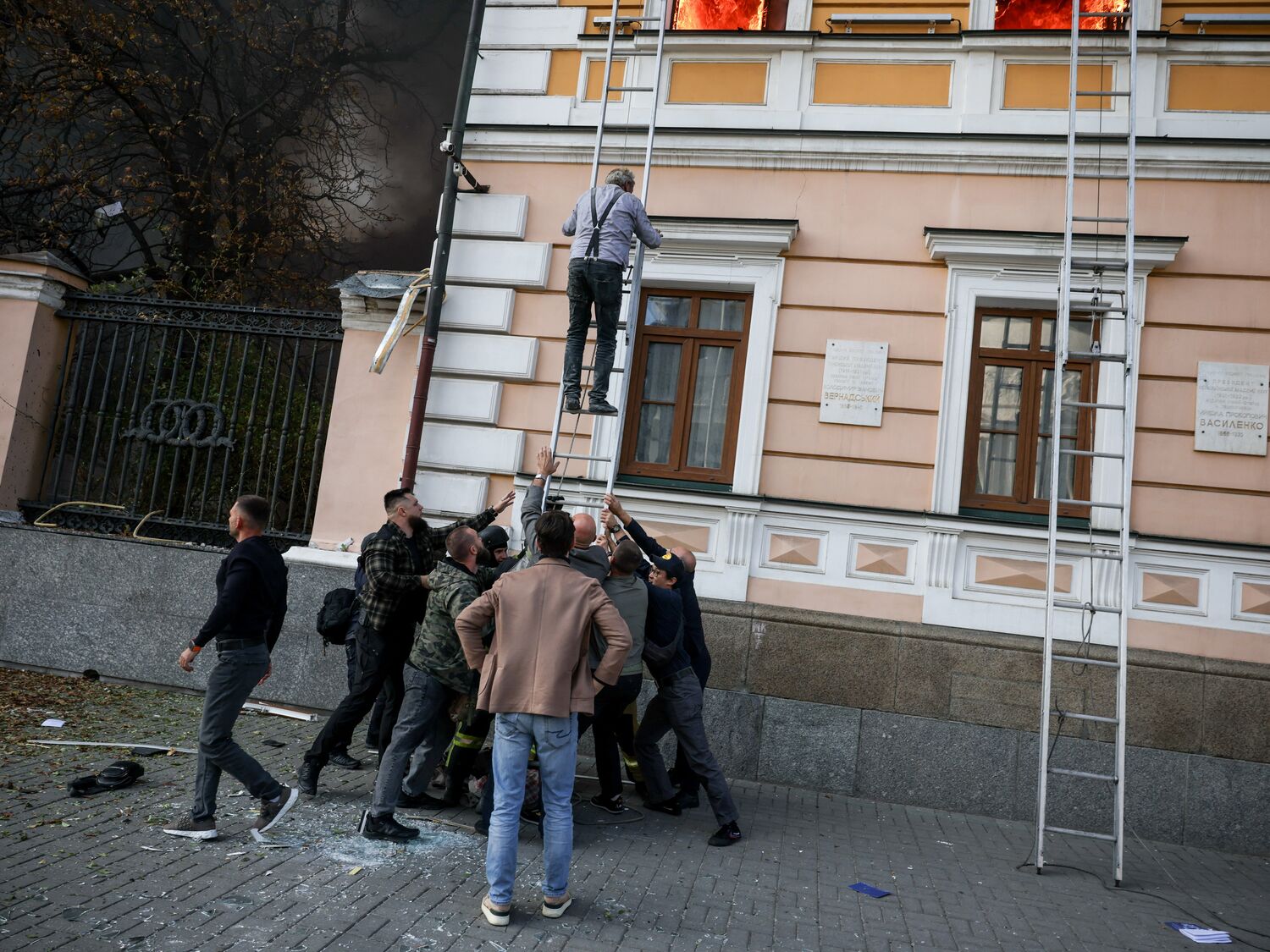 A man uses a ladder at the site of an administrative building hit by a Russian jet-powered drone strike, amid Russia's attack on Ukraine, in Kyiv, Ukraine, September 28, 2026. REUTERS/Thomas Peter