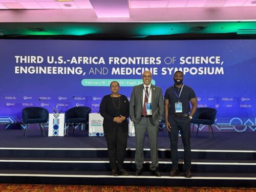 Hussam, Asmeret, and Jamaji smiling and standing next to each other for a photograph.