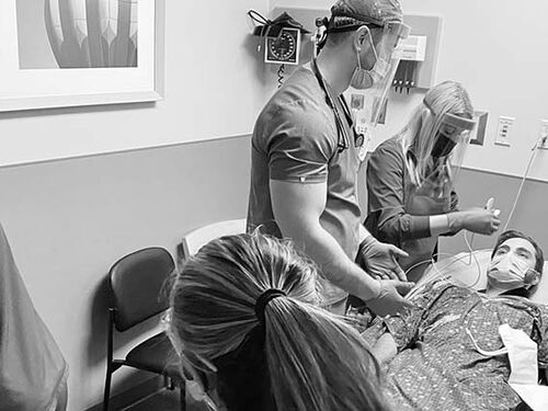 Doctors and nurses working on a patient in the ER