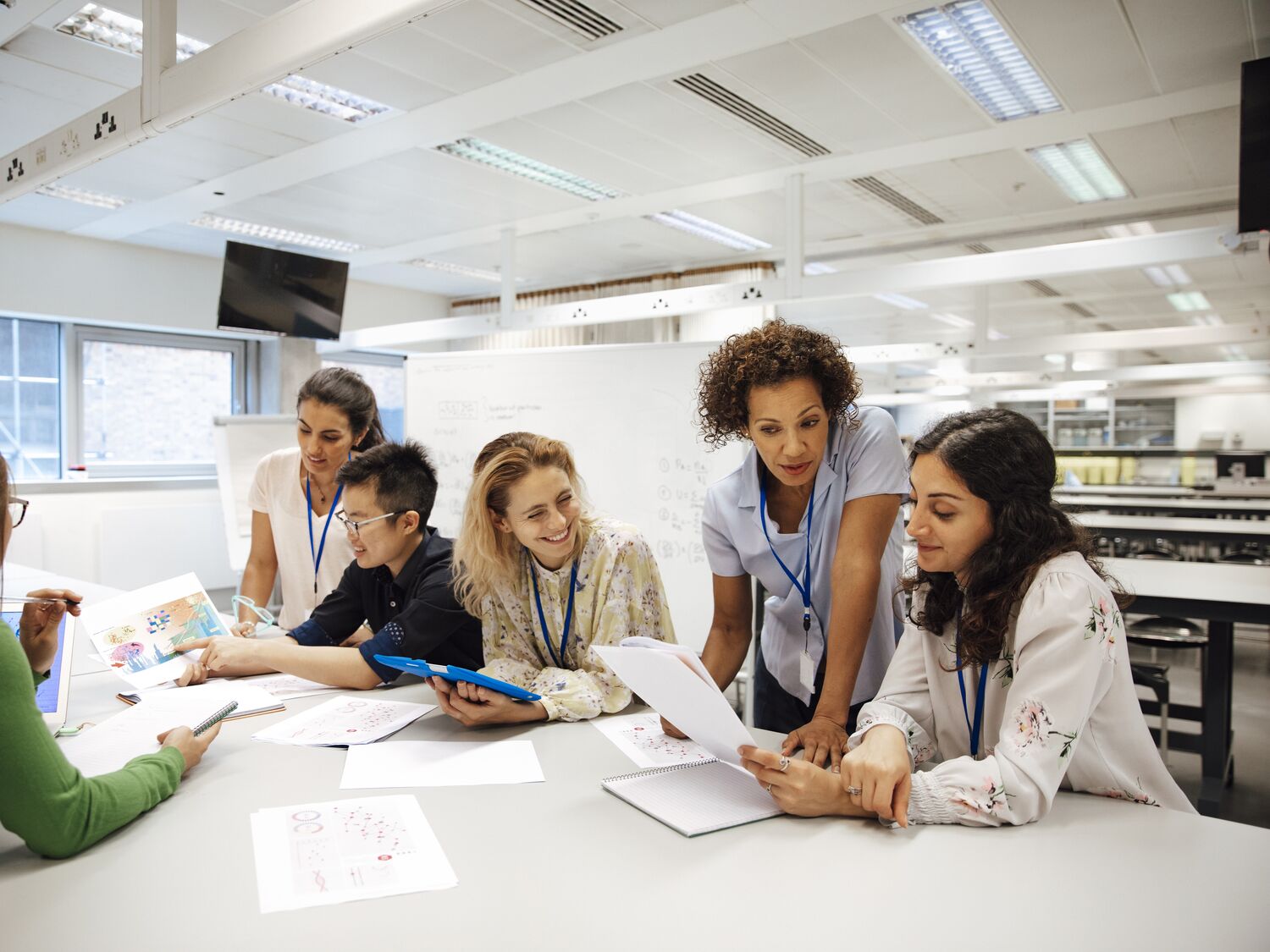 A group of people collaborating and looking at papers together.