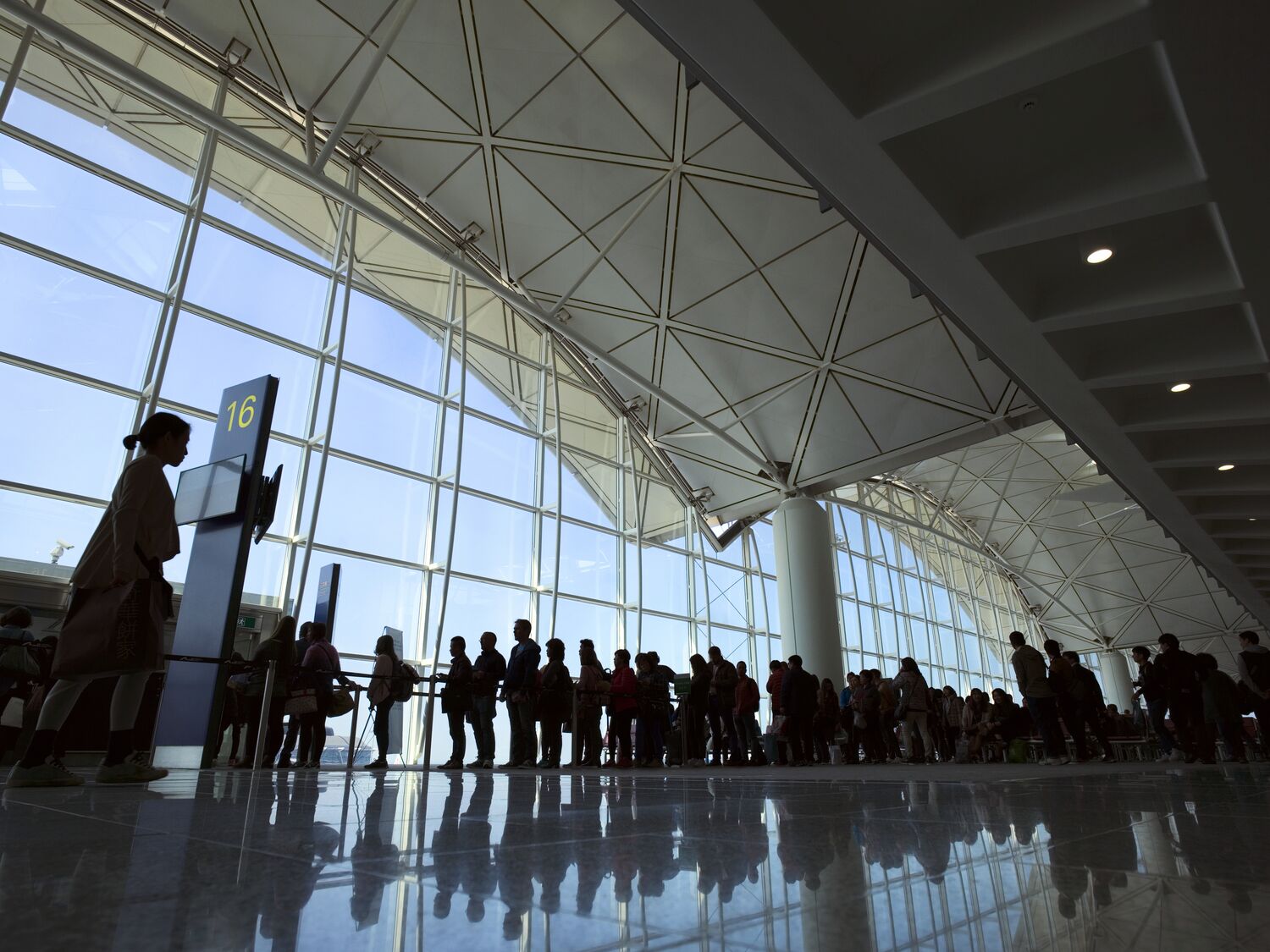 People entering airplane at gate of modern airport