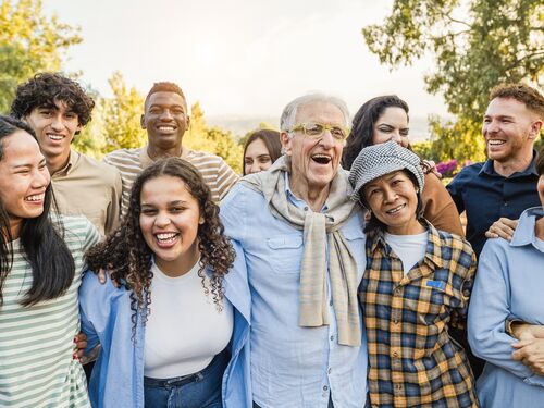 Group of multigenerational people smiling in front of camera.
