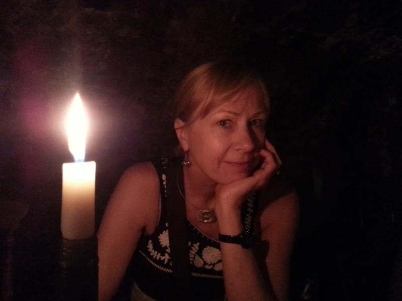 Headshot of Susan Lee next to a lit candle.