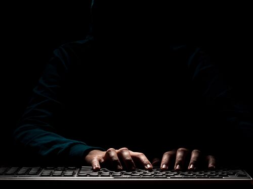 Unknown person hands using a keyboard sends message with intimidating and threatening to the interlocutor