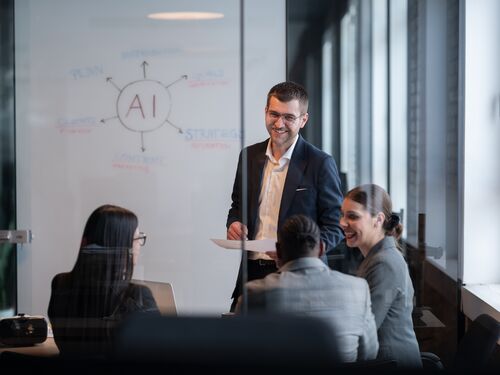 Diverse business team in a modern office during a meeting, discussing artificial intelligence strategy. Concept of AI innovation, teamwork, leadership, corporate planning, professional collaboration.