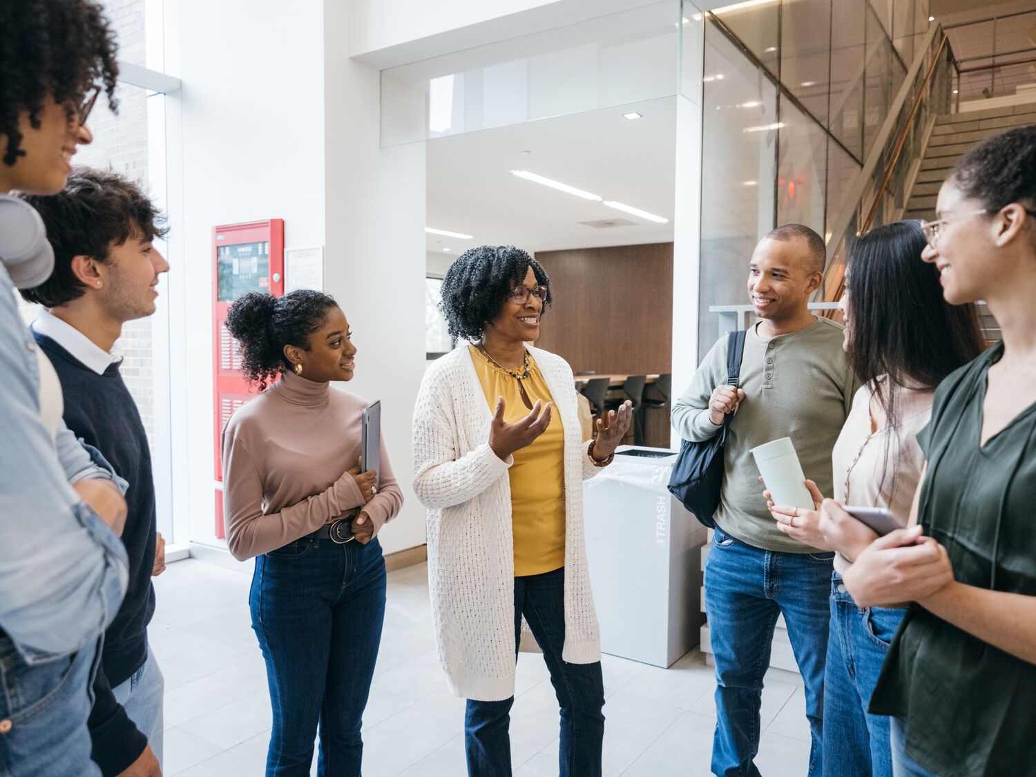 Teacher talks to students in University lobby