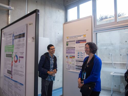 Two people smiling while talking about a chart.