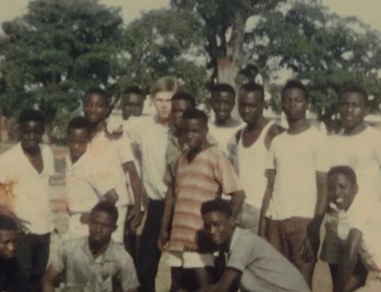 Frank McCormick stands among a group of fourteen secondary school students.