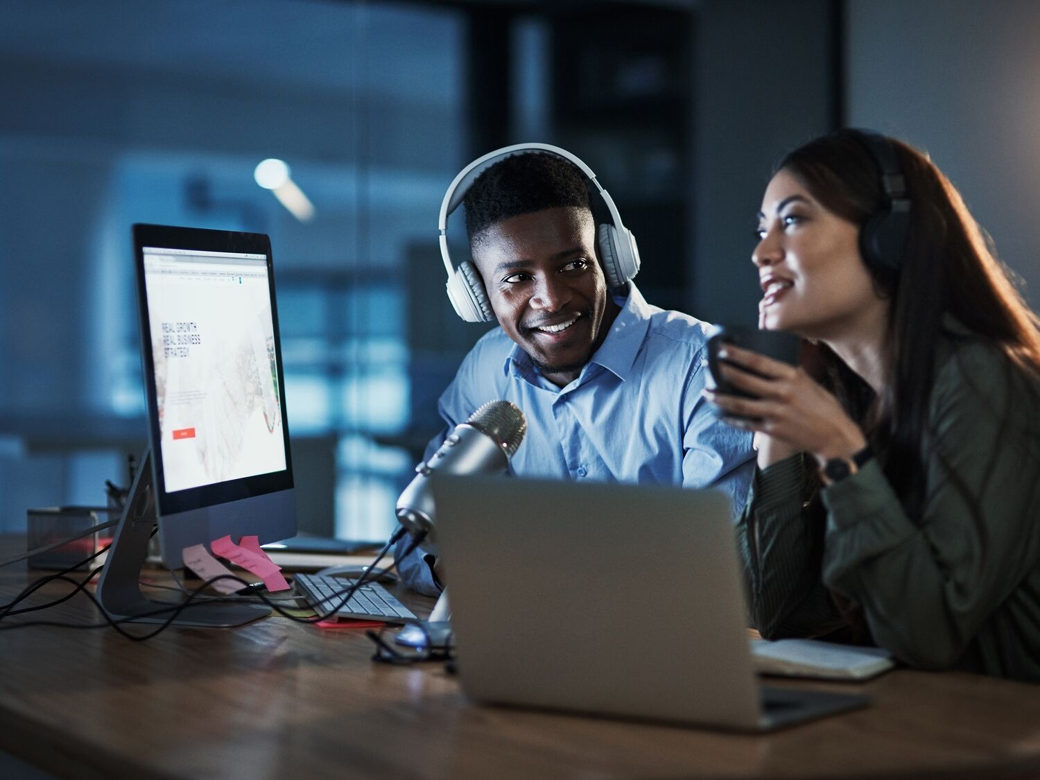 Shot of two people doing a broadcast while sitting in an office at night