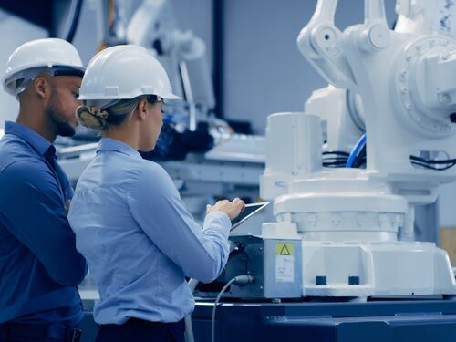 Engineering, tablet and people in automation lab with machine for analysis, research and inspection. Technology, collaboration and man and woman on digital tech for robotic ai, equipment and software