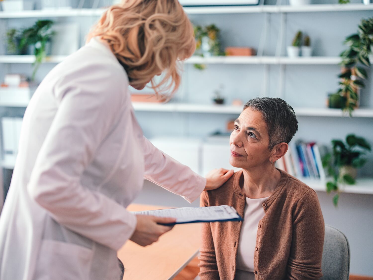 Doctor Comforting a Female Patient in a Modern Office Setting.