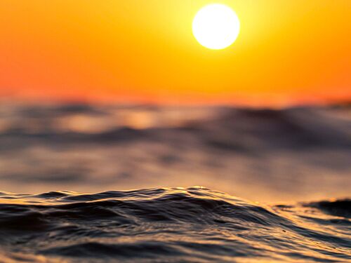 low sun hanging over a sea or ocean