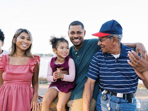 Happy and smiling multiracial family with grandparents by the beach in New England
