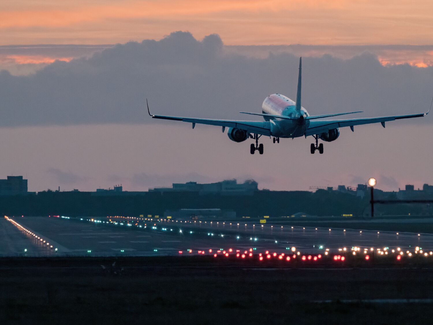 Airplane landing at sunrise.