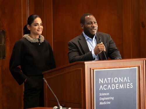 Kiana Aran and Ayodeji Coker standing behind podium addressing an audience.