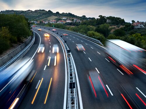 Traffic On Highway At Dusk, With Blurred Cars And Trucks
