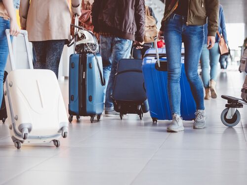 Group of people walking with suitcase at airport terminal