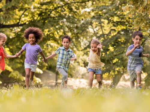 Small happy kids having fun while running in nature.