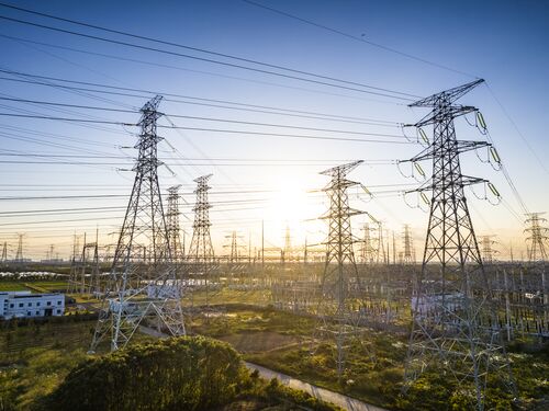 High-voltage towers and electricity power lines against the blue sky