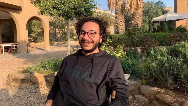 Ahmed sitting outside smiling.