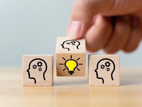 Concept creative idea and innovation. Hand flip over wooden cube block with head human symbol and light bulb icon