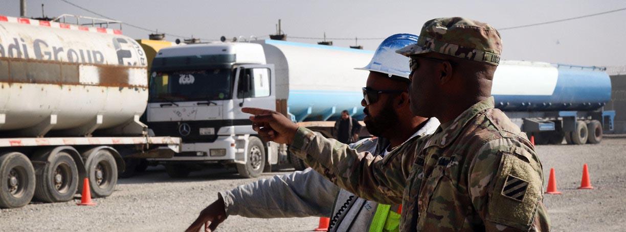 Army personnel coordinating fueling trucks